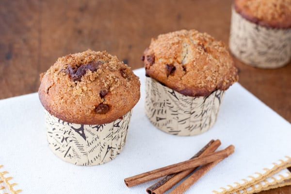 3 cinnamon muffins with chunks of cinnamon chips and crunchy cinnamon and sugar on top