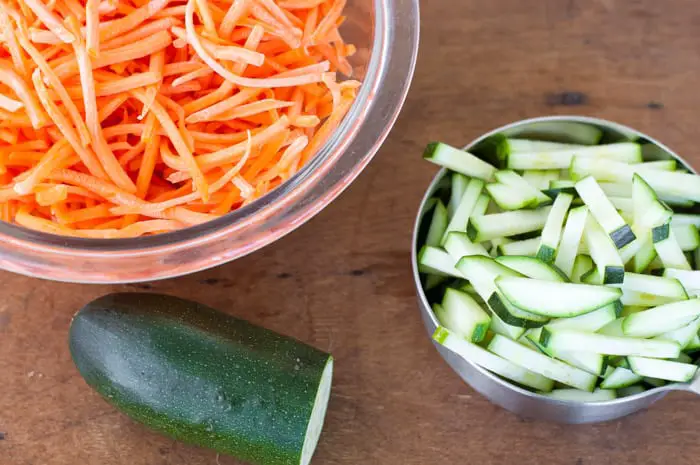 top view of bowls of julienned carrots and zucchini