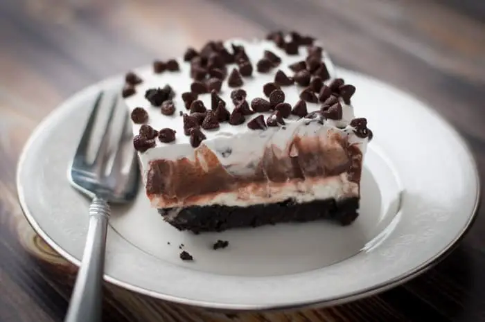 Slice of chocolate lasagna on a white plate with a fork