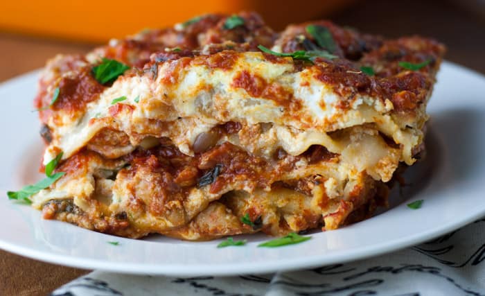 Side view of slice of no boil turkey lasagna showing all the layers on a white plate