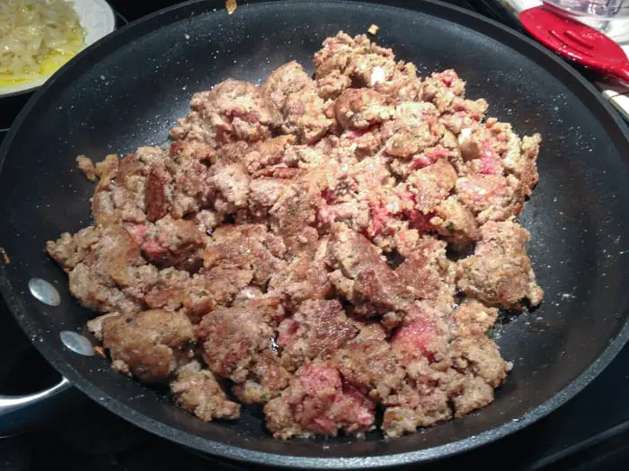 nonstick skillet with broken meatballs broken down into smaller pieces