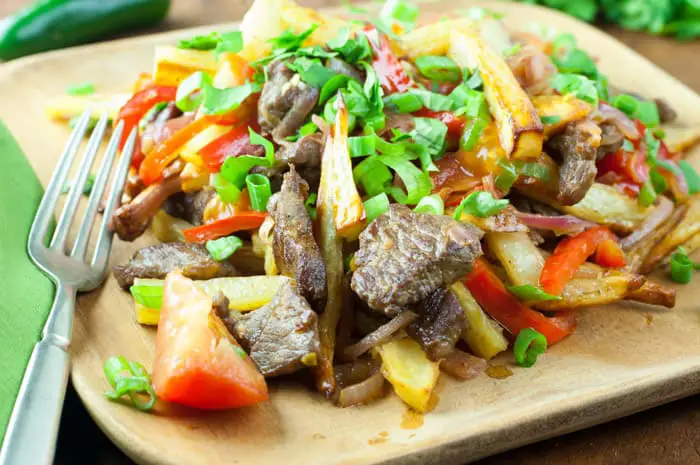 Lomo Saltado - a Peruvian beef stir-fry with bold flavors. Top with Peruvian Green Sauce or Salsa Criolla - one of my favorite dishes from El Pollo Inka