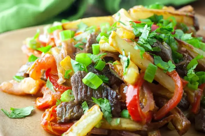 Lomo Saltado - a Peruvian beef stir-fry with bold flavors. Top with Peruvian Green Sauce or Salsa Criolla - one of my favorite dishes from El Pollo Inka