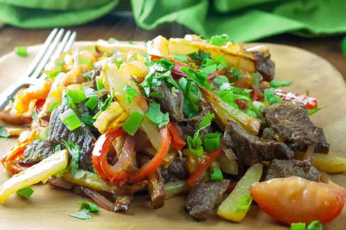 Lomo Saltado - a Peruvian beef stir-fry with bold flavors. Top with Peruvian Green Sauce or Salsa Criolla - one of my favorite dishes from El Pollo Inka