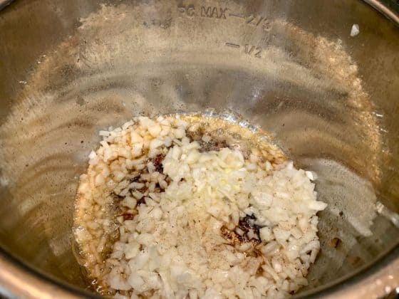 Chopped raw onions sauteing in an Instant Pot