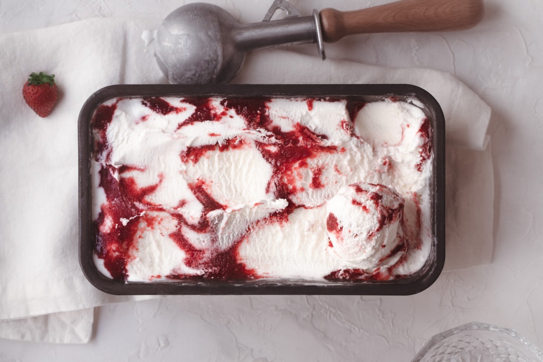Rectangle ice cream container filled with creamy white and red swirled ice cream